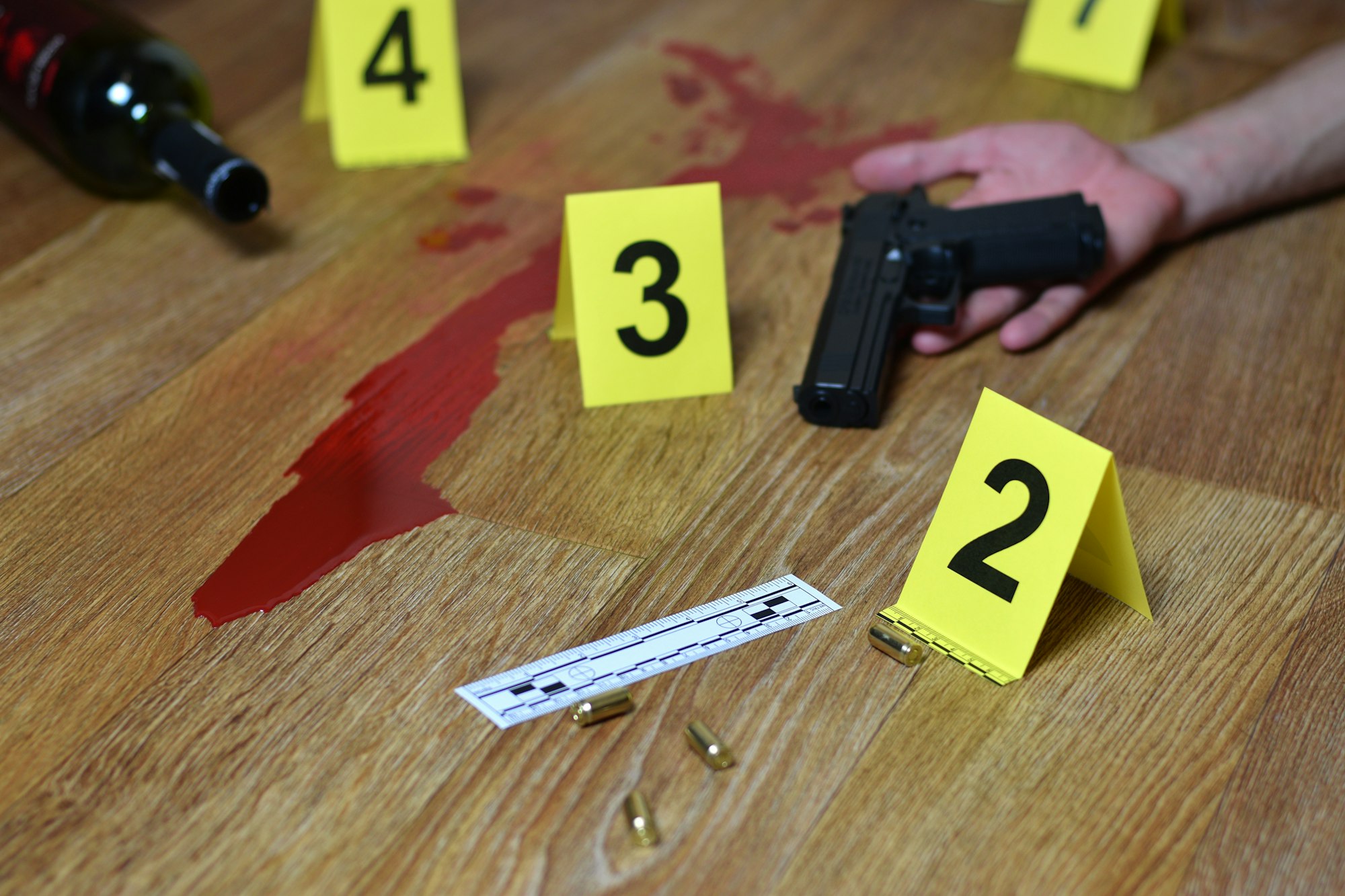 Bloody crime scene with dead body and gun on floor